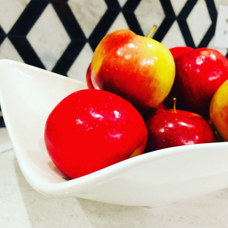 Red apples in a white bowl is an edible kitchen island decor option.