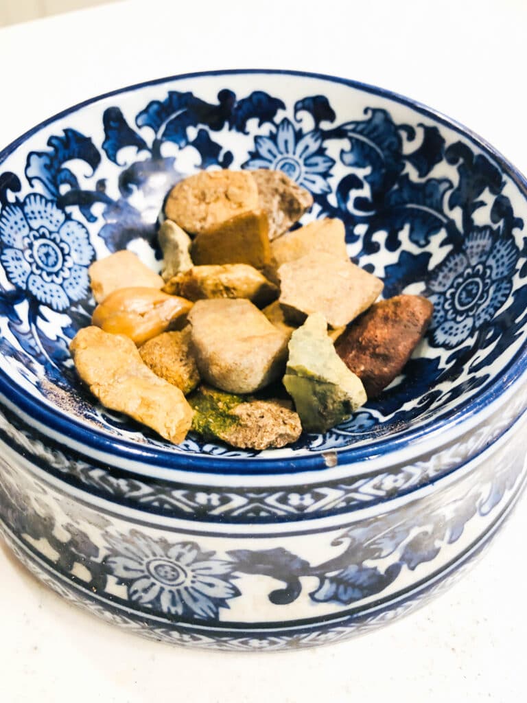 A dog bowl with a thin layer of rocks on the bottom.