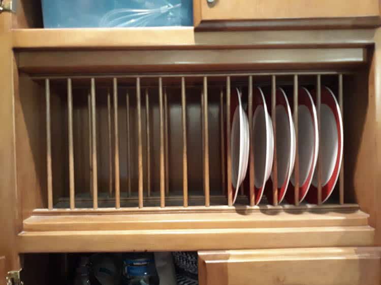 A dark wood built-in plate rack.