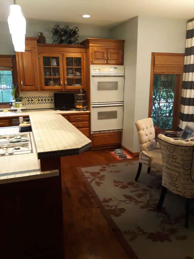 A dark kitchen with glass front cabinets before the renovation.