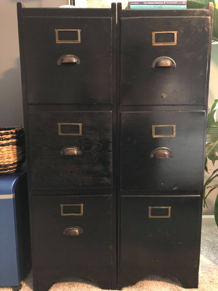 Two old wood file cabinets that have been painted black.