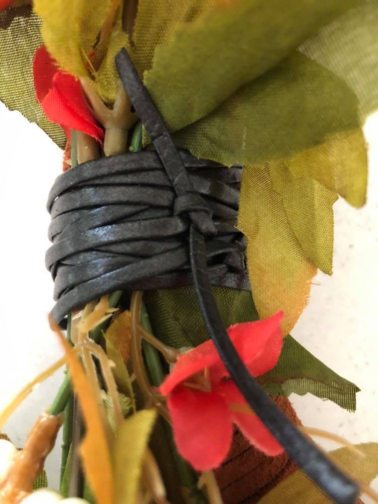 Tied faux flowers with leather lacing.