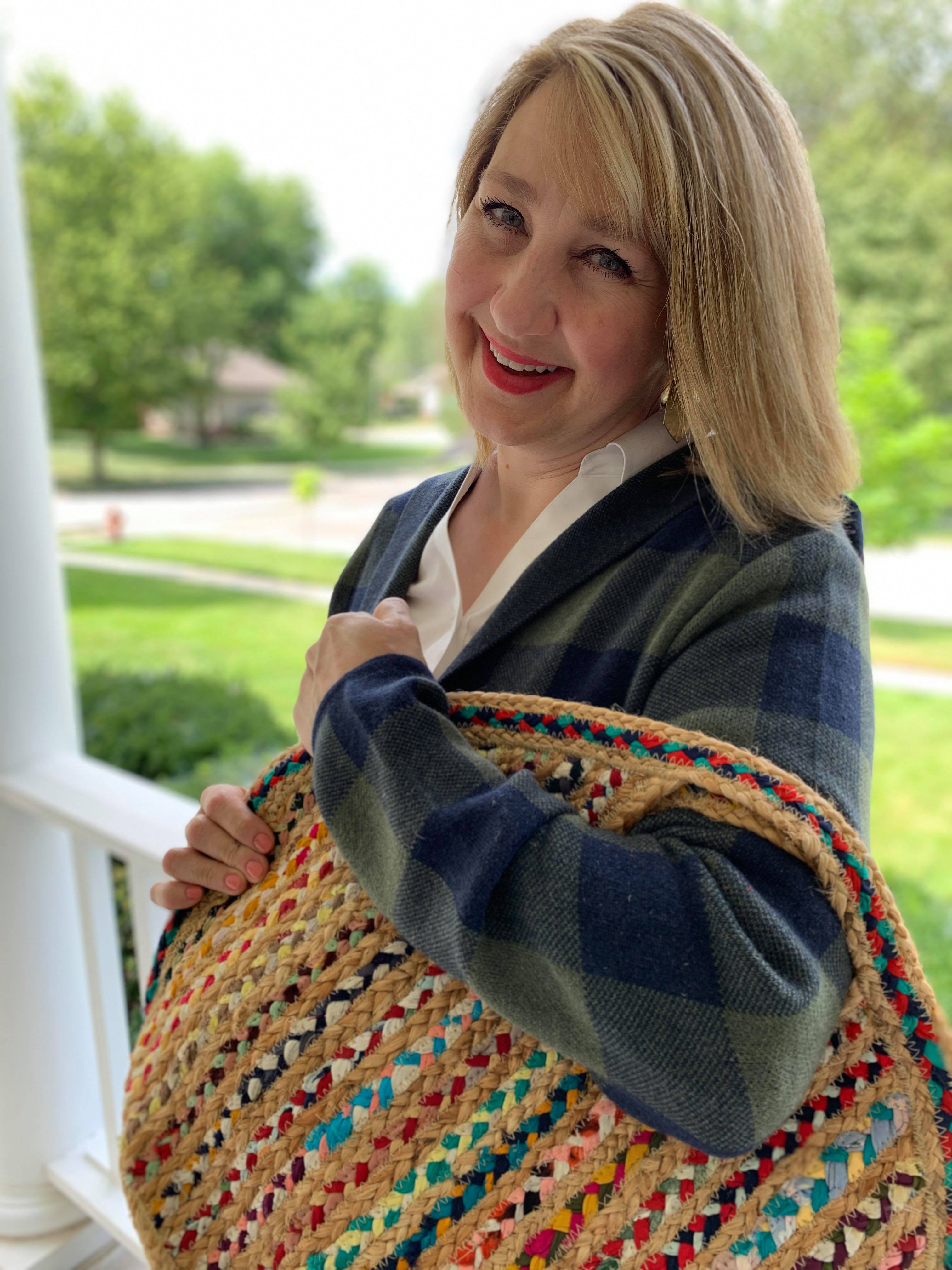 Missy holding a woven handbag.