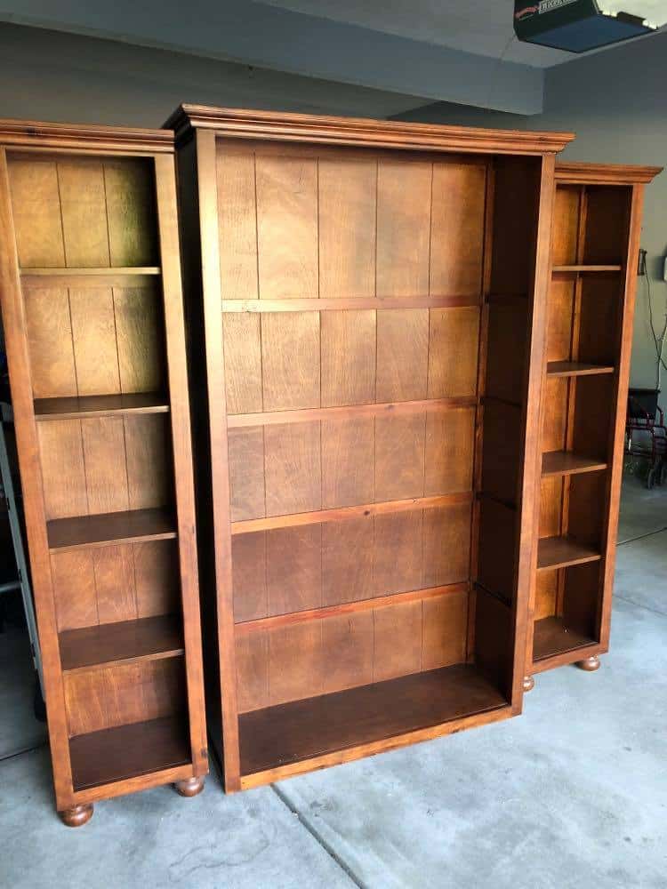 A before photo of an old bookcase before its makeover made of particle board and wood.
