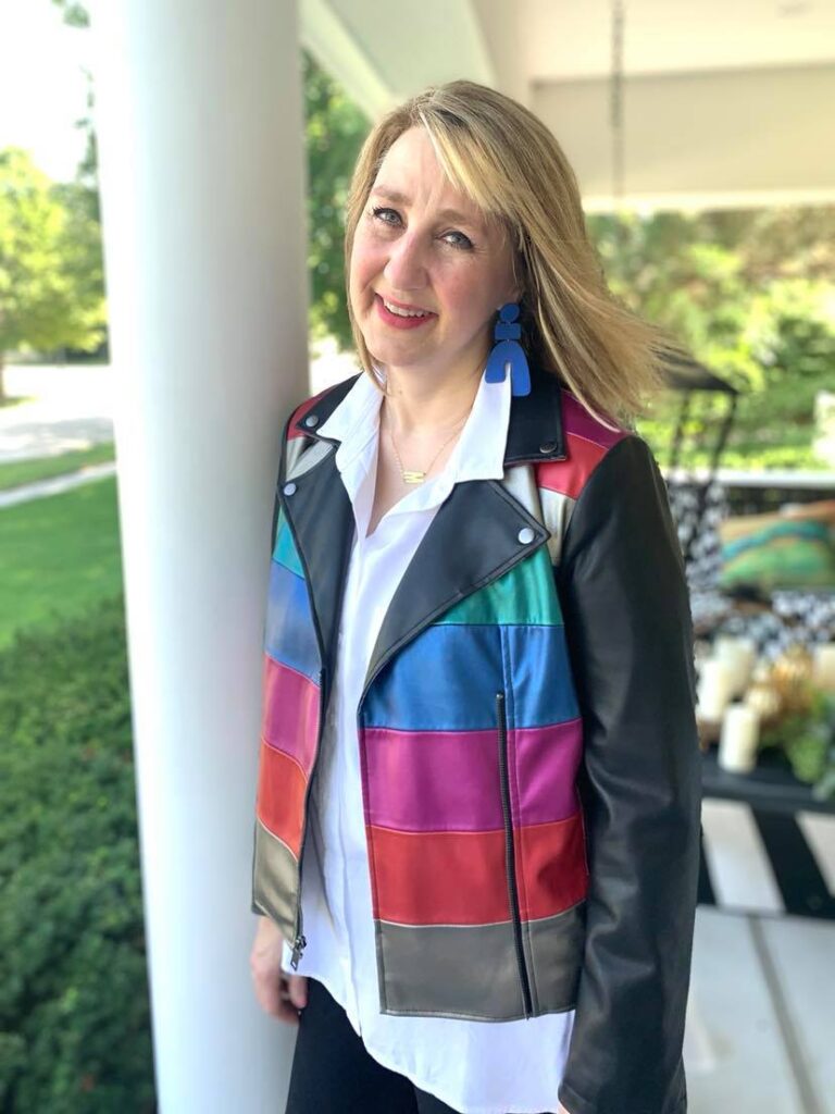 Color blocked leather moto jacket and blue earrings.