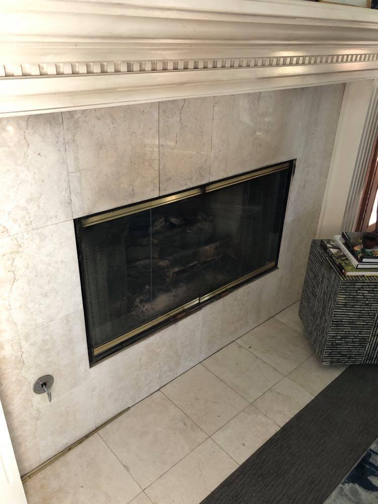 Fireplace with dingy tile and discolored moulding that is part of this before and after diy fireplace makeover.