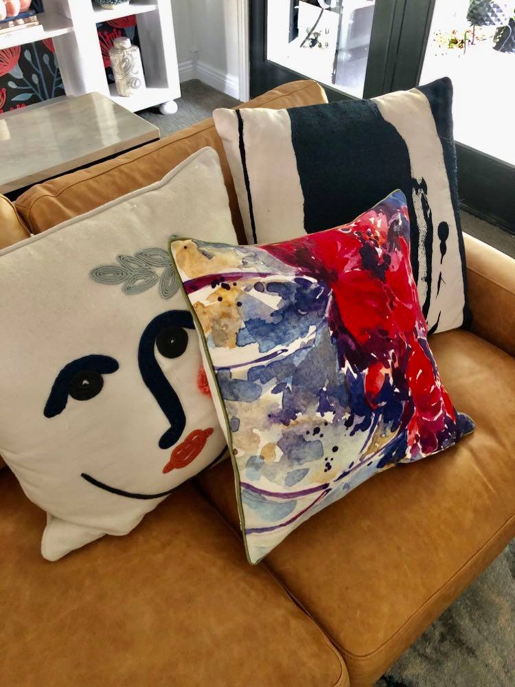 Bright pillows are perfect on this brown leather sofa.