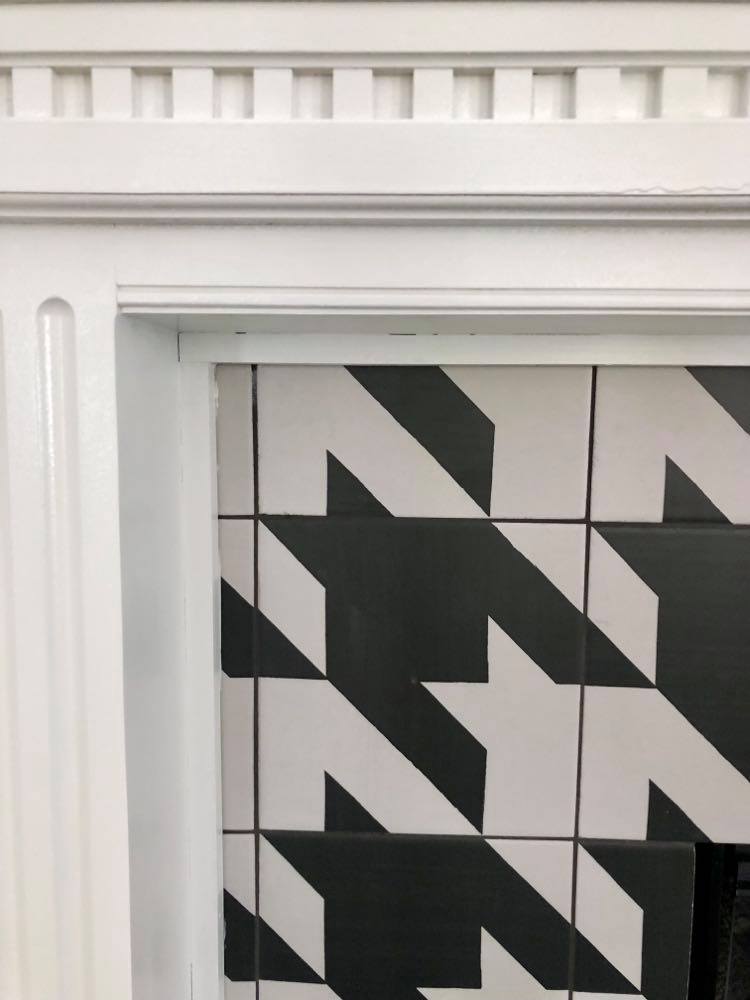 Grey/black grout lines between the tiles were a design decision for this before and after diy fireplace makeover.