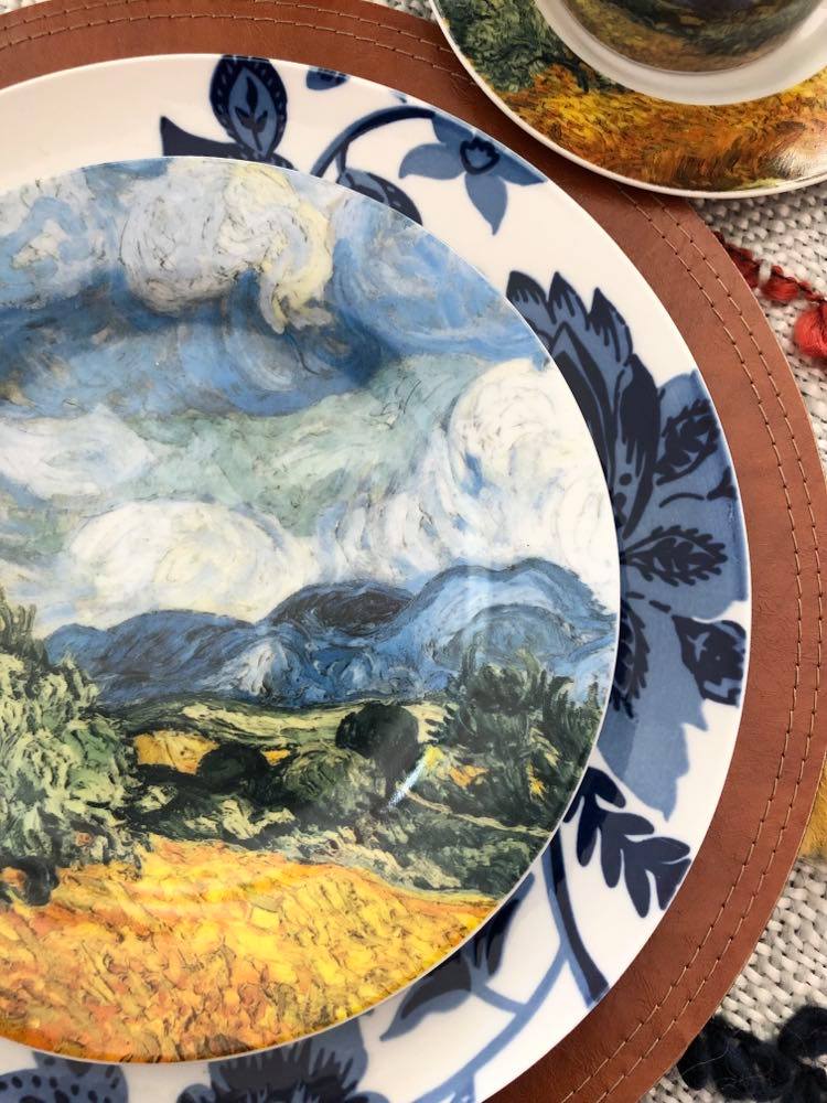 Colorful plates in a blue and white pattern as well as artwork by Van Gogh.