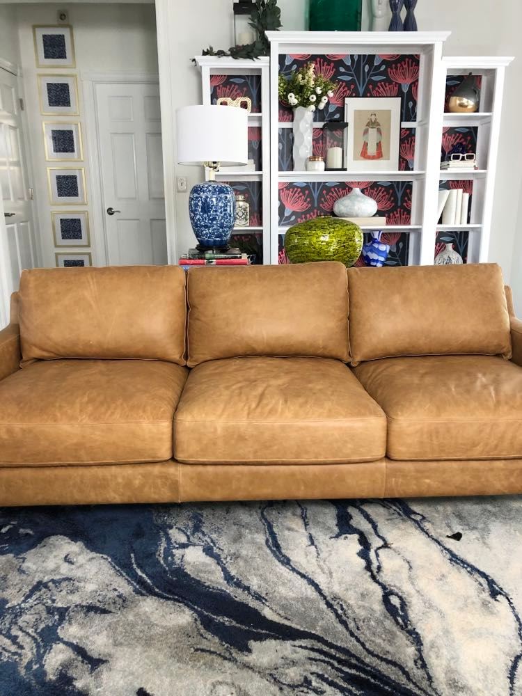 A brown leather sofa without any pillows.