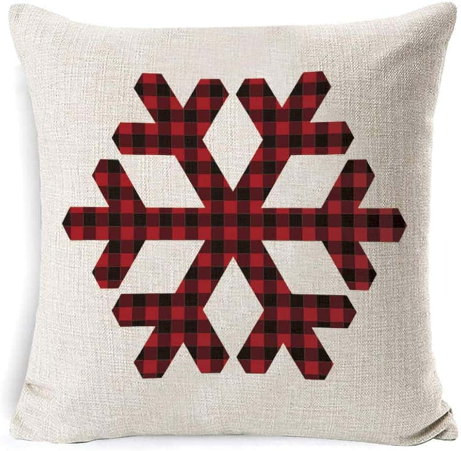 A red and black plaid snowflake on a white pillow.