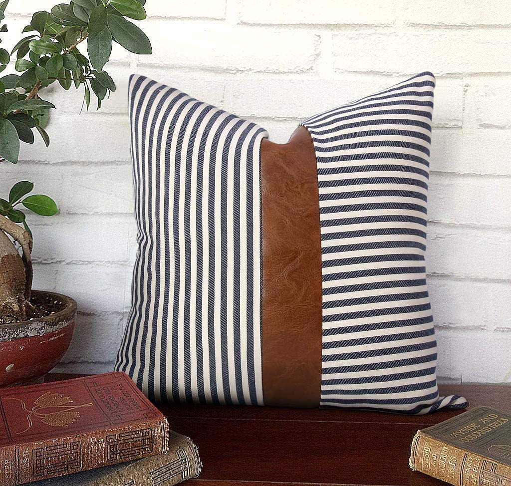 A navy blue stripe pillow with a leather stripe in the middle.