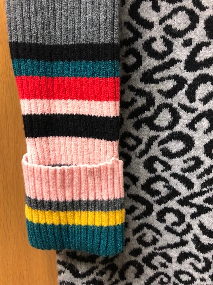 The multi colored, striped sleeve that will be cut from the sweater to create a sweater weather candle cozy.
