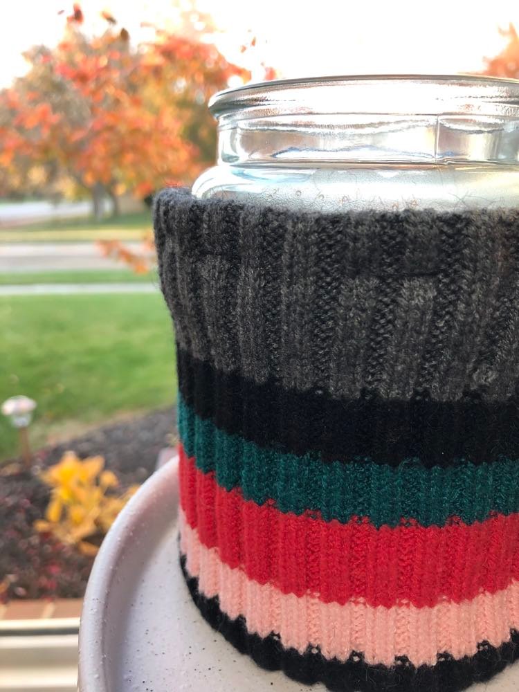 Striped sweater fabric in black, grey, red, and pink.