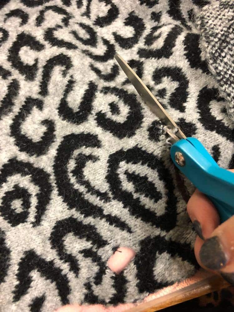 Cutting the animal print sweater fabric.