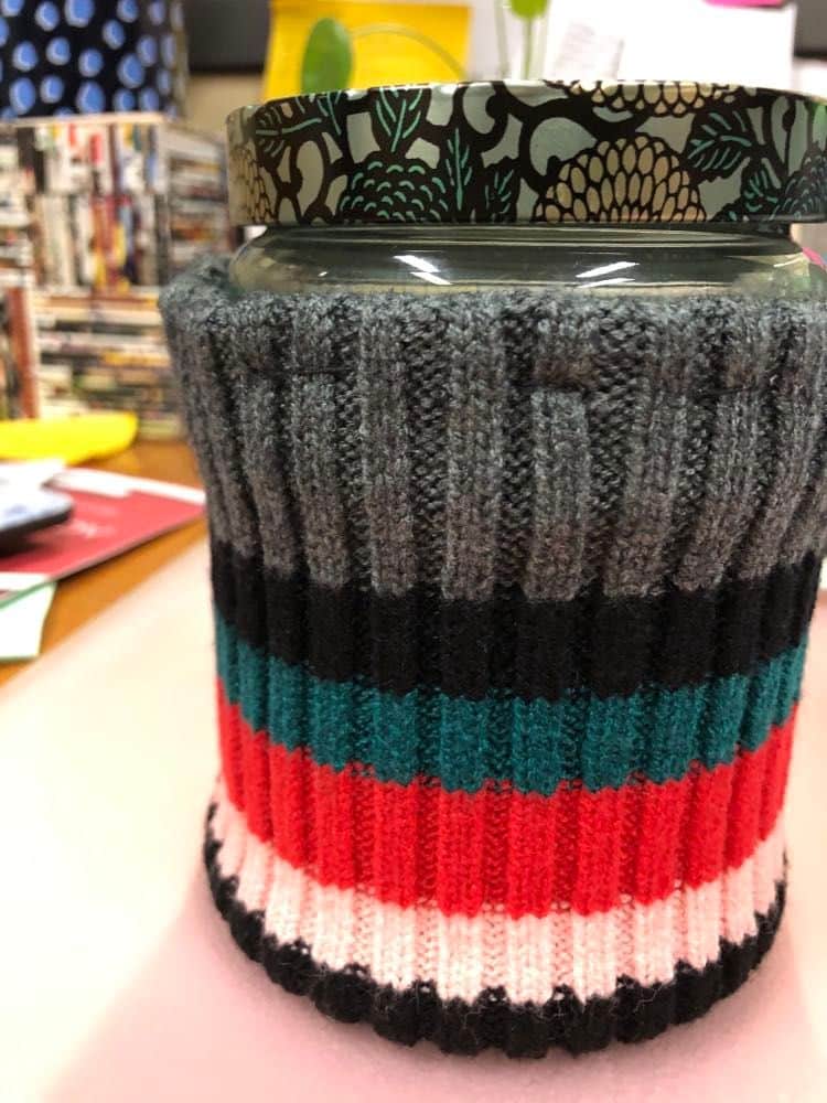 The finished sweater weather candle wrap on a jar candle.