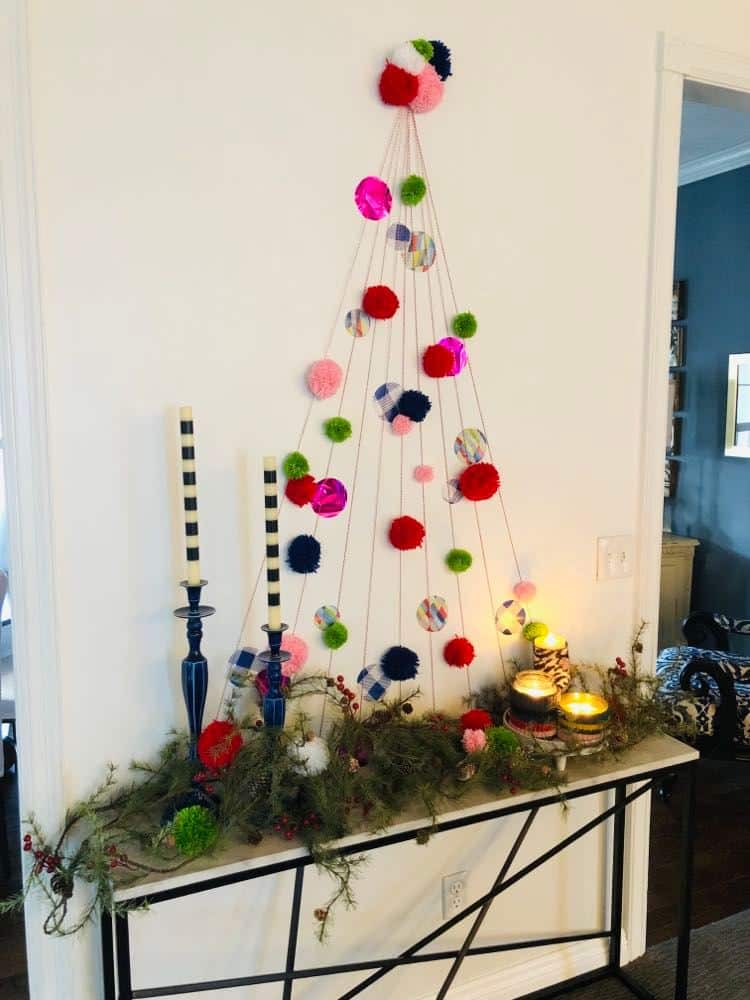 A DIY wall Christmas tree
displayed with candlesticks and jar candles.