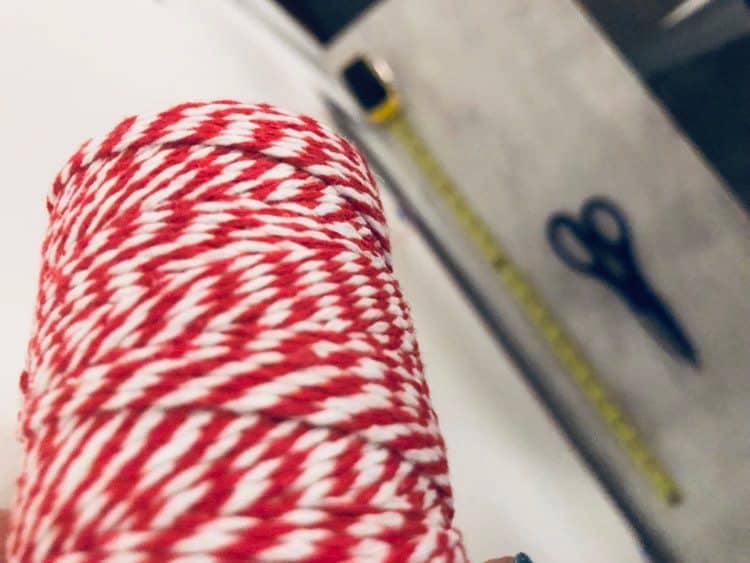 Red and white twine with a measuring tape and scissors.