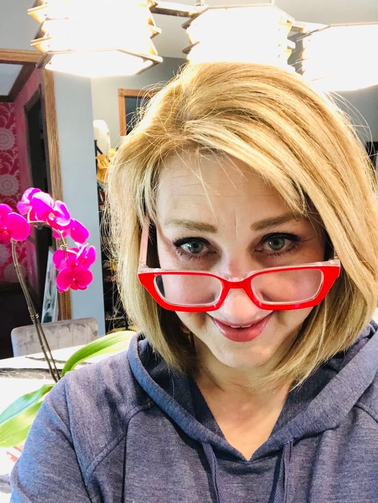 Wearing red reading glasses in the kitchen.