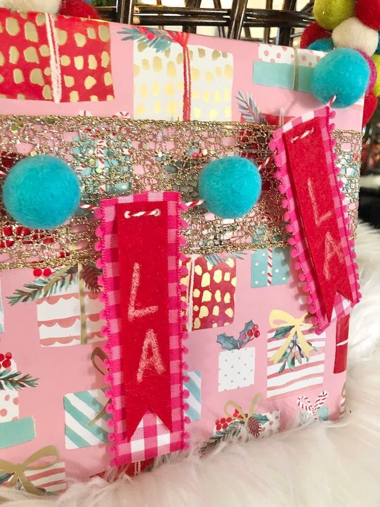 Felt "Fa La La" banner on a Christmas package.