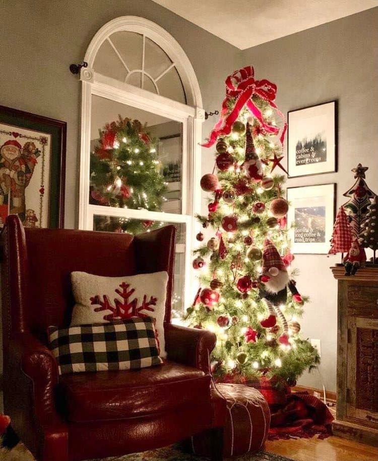 A red chair beside a glowing Christmas tree.