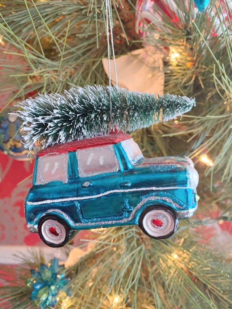 An ornament in the shape of a car with a tree tied to the top.