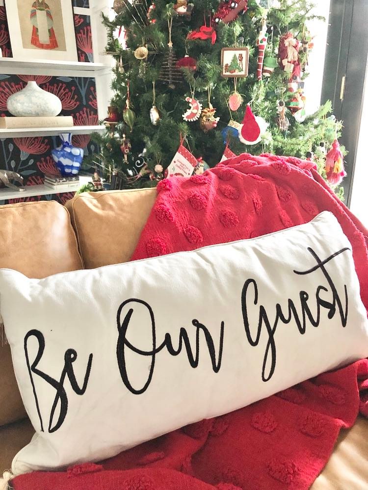 A welcoming sofa pillow that says "Be Our Guest."