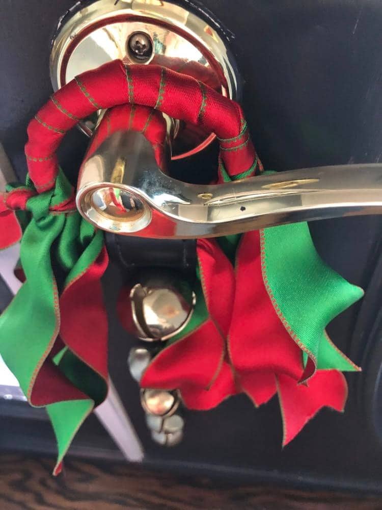Jingle Bells hanging from a doorknob to welcome guests.