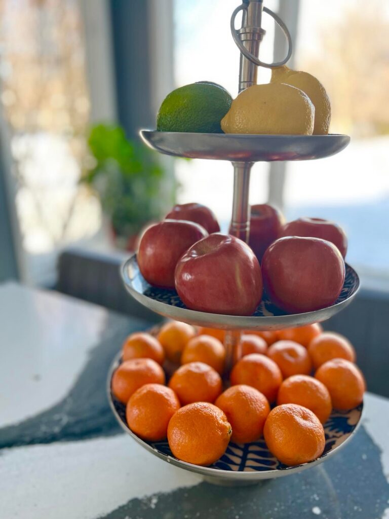 A three tier tray full of fresh fruit to transition from Christmas to winter docor.