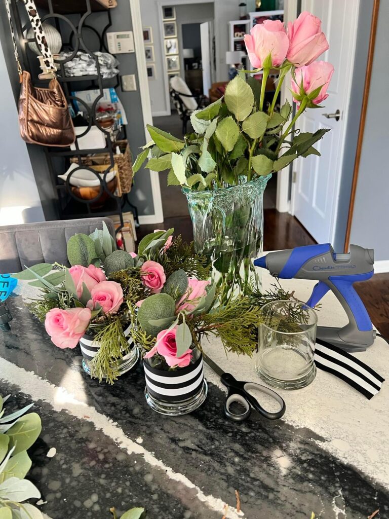 The vases, ribbons, and roses used to create the small flower arrangement.