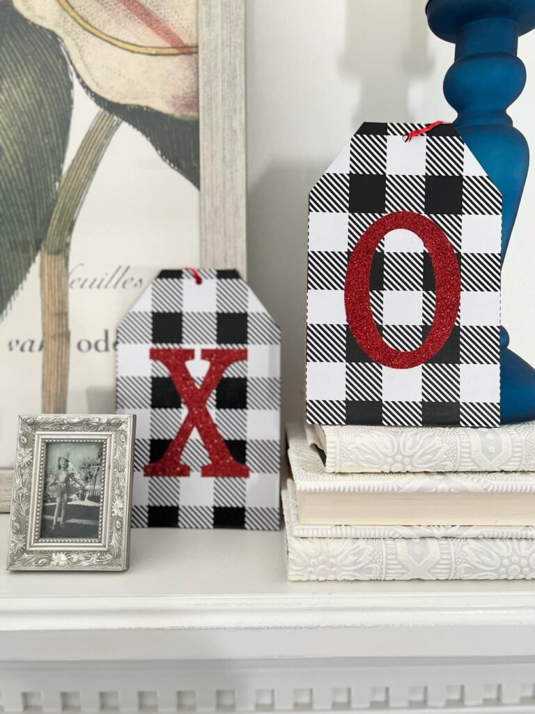 Decorate for Valentine's Day with buffalo check wooden tags with "x" and "O" written on them in red glitter.