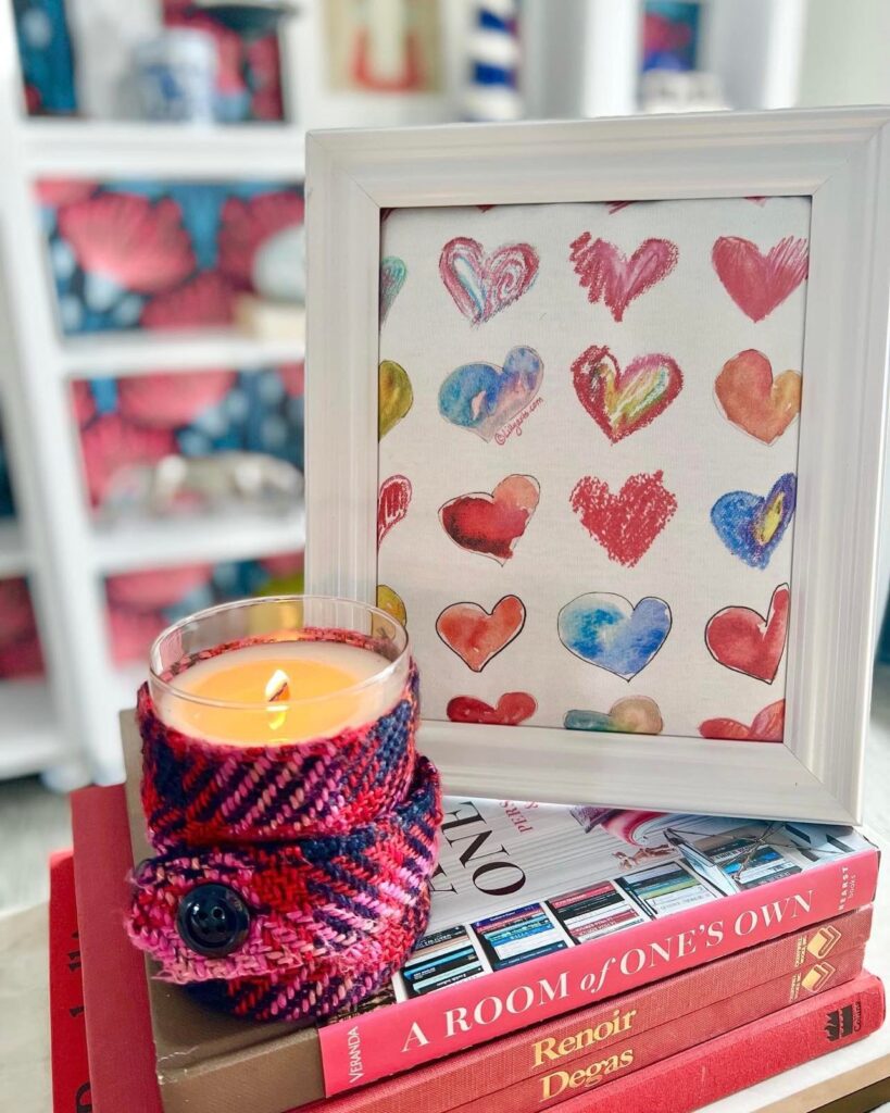 Framed heart fabric on a stack books beside a candle is a great DIY Valentine's Day home decor idea.