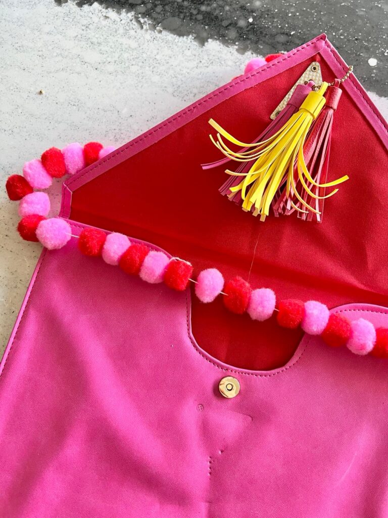 The pom-pom garland draped across a purse pouch.