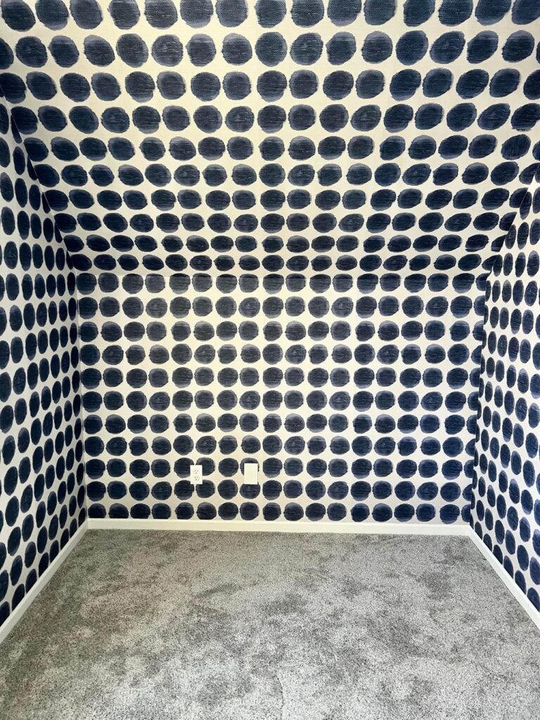 The nook of the room wallpapered with blue dot wallpaper.