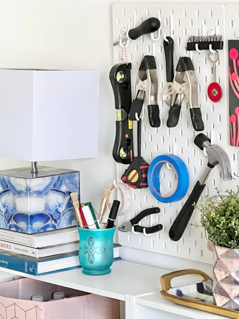 A variety of tools hanging on a pegboard for efficient craft room storage.