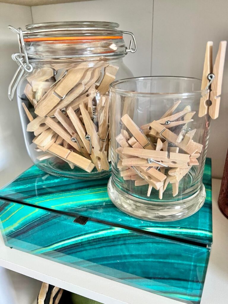 Glass jars holding clothespins are an example of craft room storage.