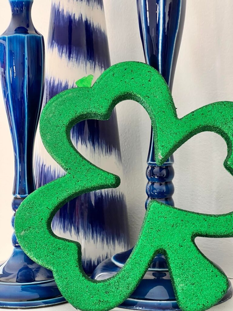 Green shamrock resting against blue vases.