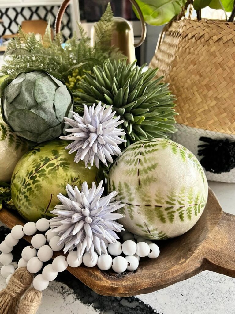 Green and white fern imprinted balls in a dough bowl with a white bead garland.