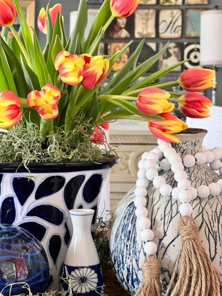 How to decorate with bead garland: White bead garland wrapped around the neck of a blue and white vase.