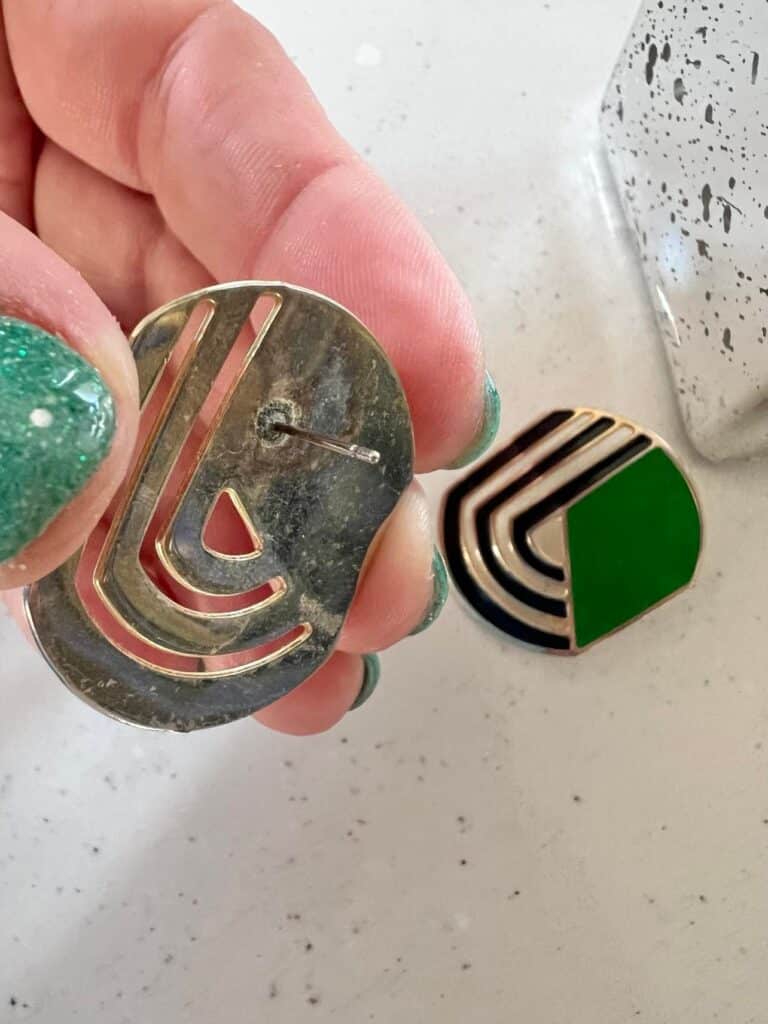 A pair of green, silver, and black earrings that will become home decor.
