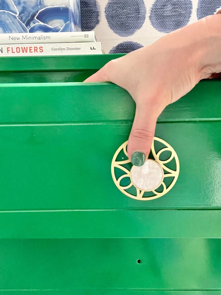 Attaching the knob and backplate to the freshly painted drawer in the dresser makeover.