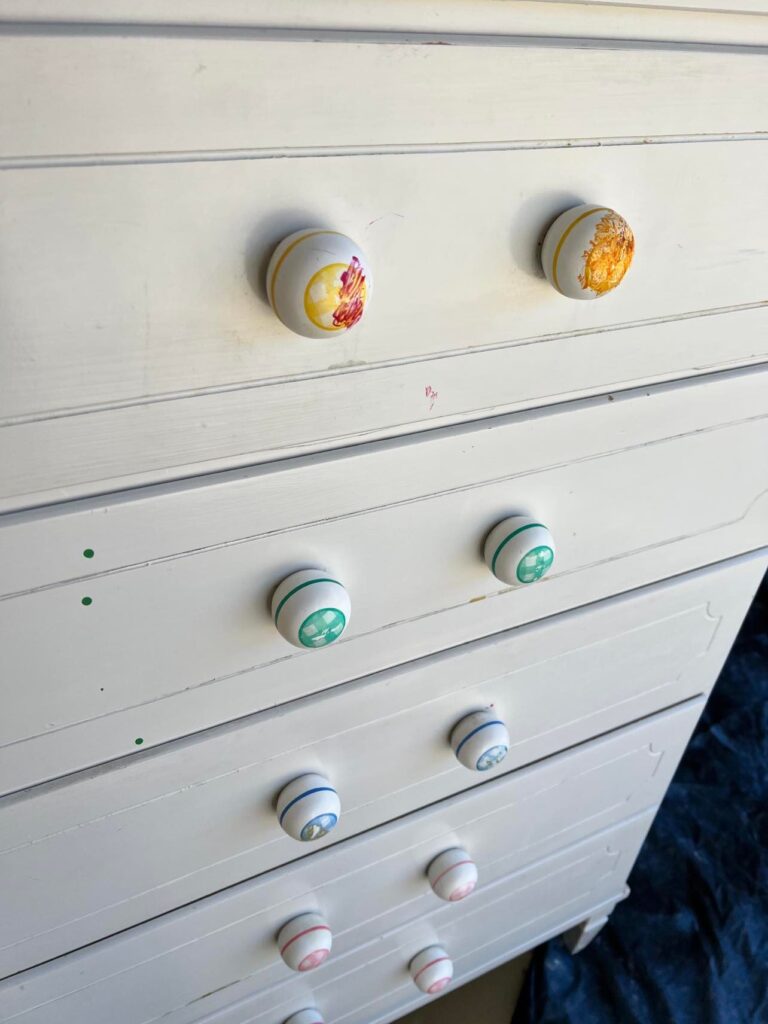 Old dresser knobs upon which a child has colored with markers.