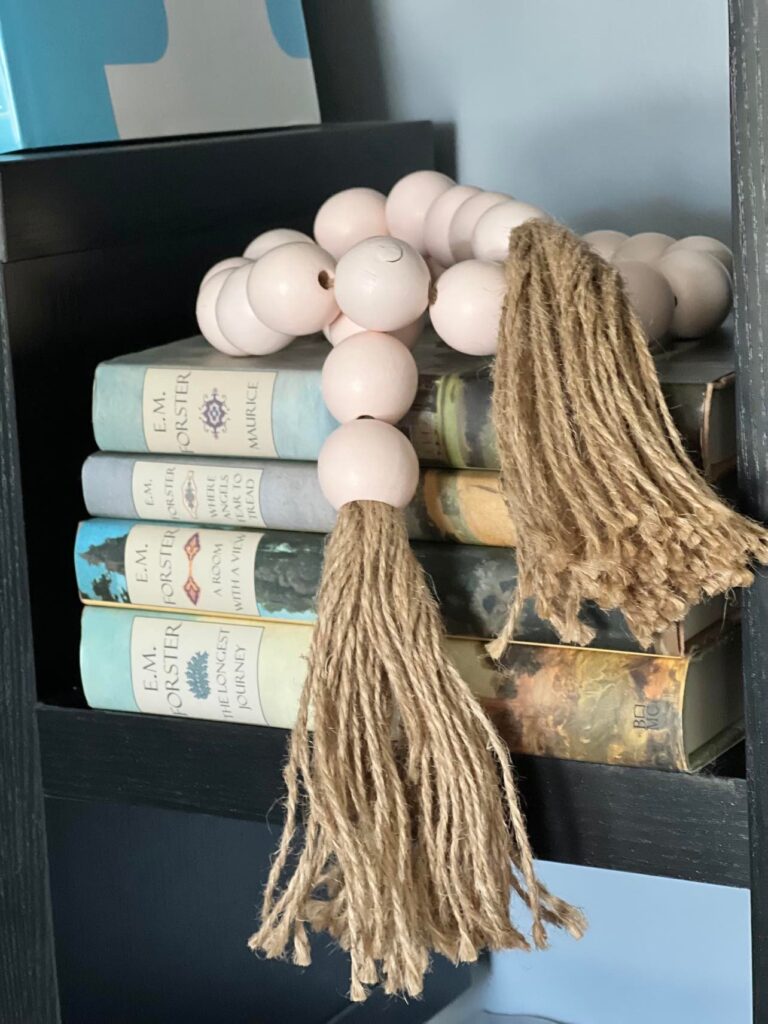 Decorating a shelf with a  bead garland sitting atop a stack of books.