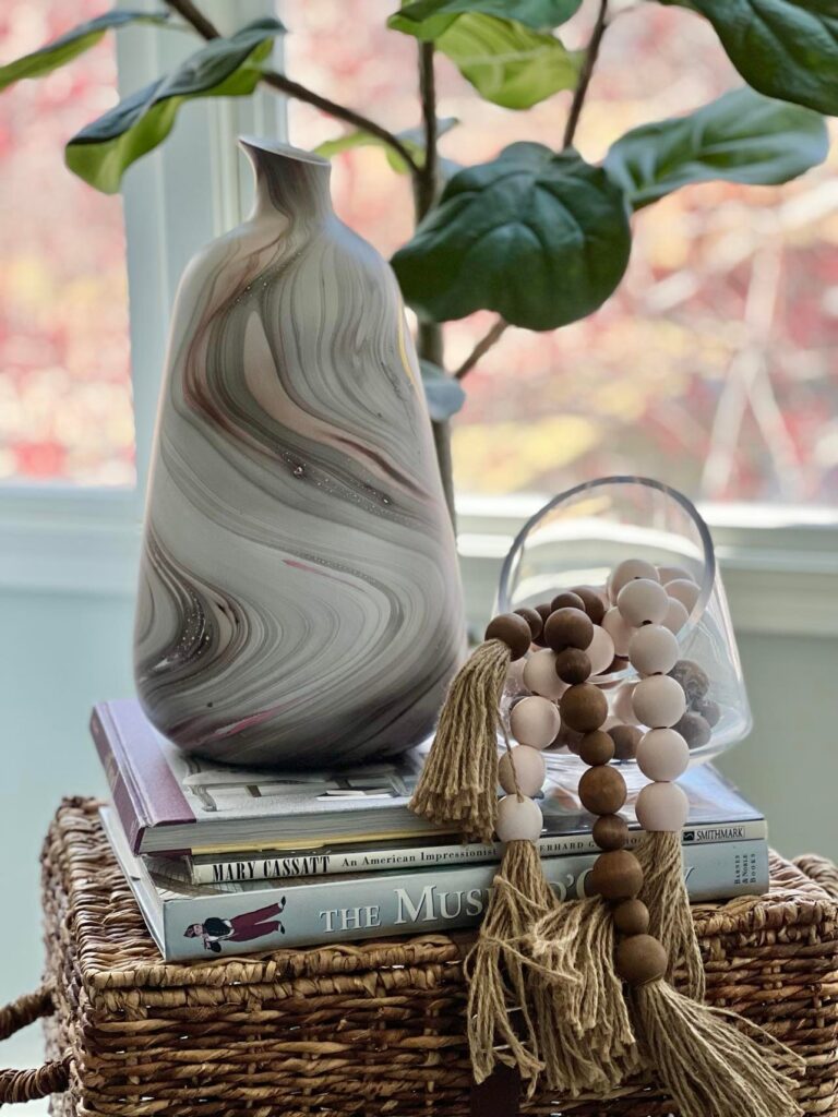 Two wood bead garlands in brown and pink piled into a glass jar.