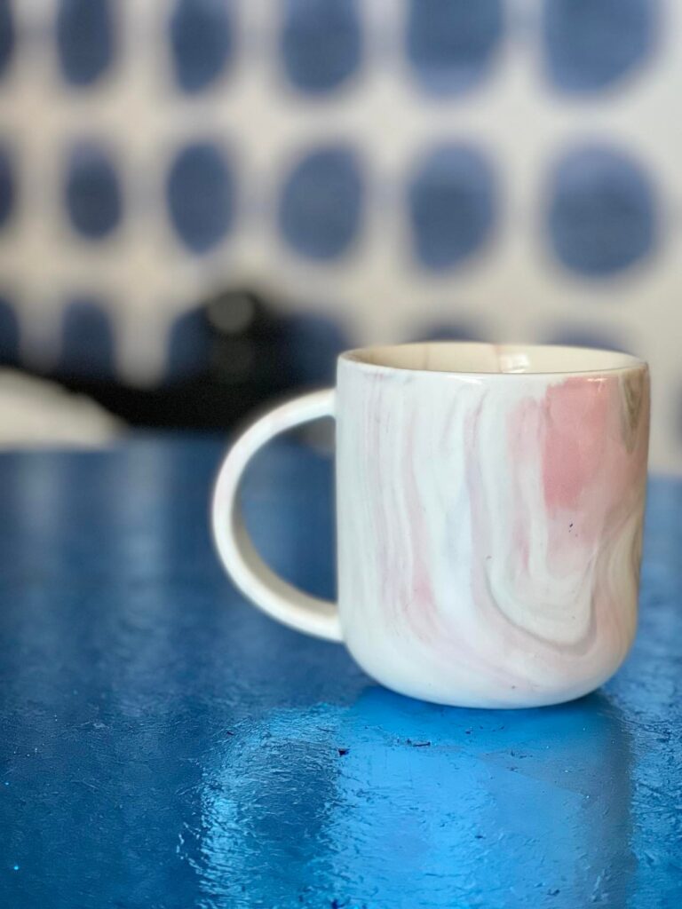 A coffee mug sitting on the foil leaf table.
