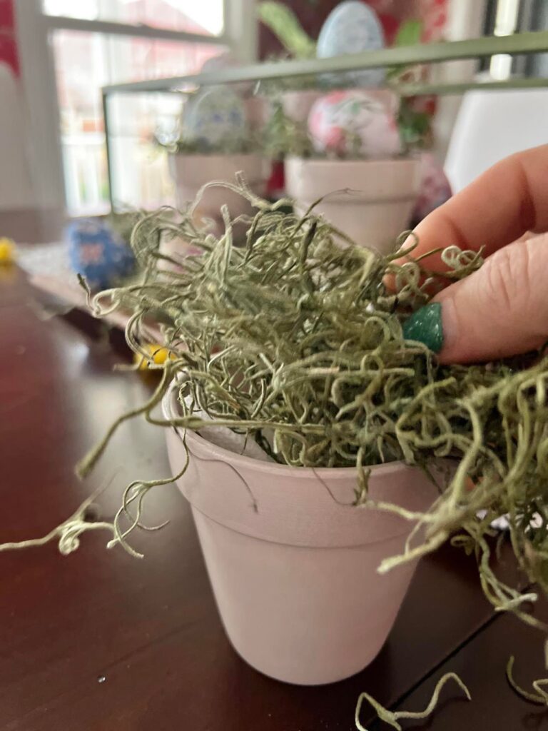 Green Spanish moss being added to the Easter table centerpiece.