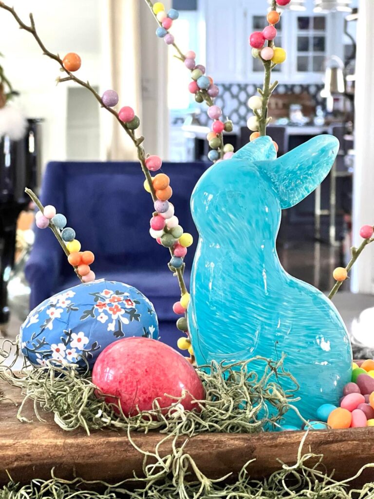 A Blue glass bunny is part of a dough bowl Easter tablescape.