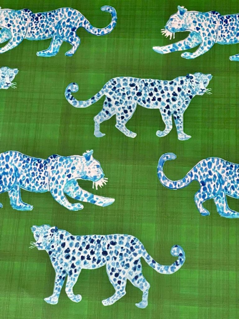 Wallpaper that includes blue spotted leopards on a green backdrop.