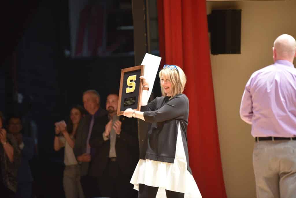 Holding a framed chenille "S" at my final concert before retiring from teaching.