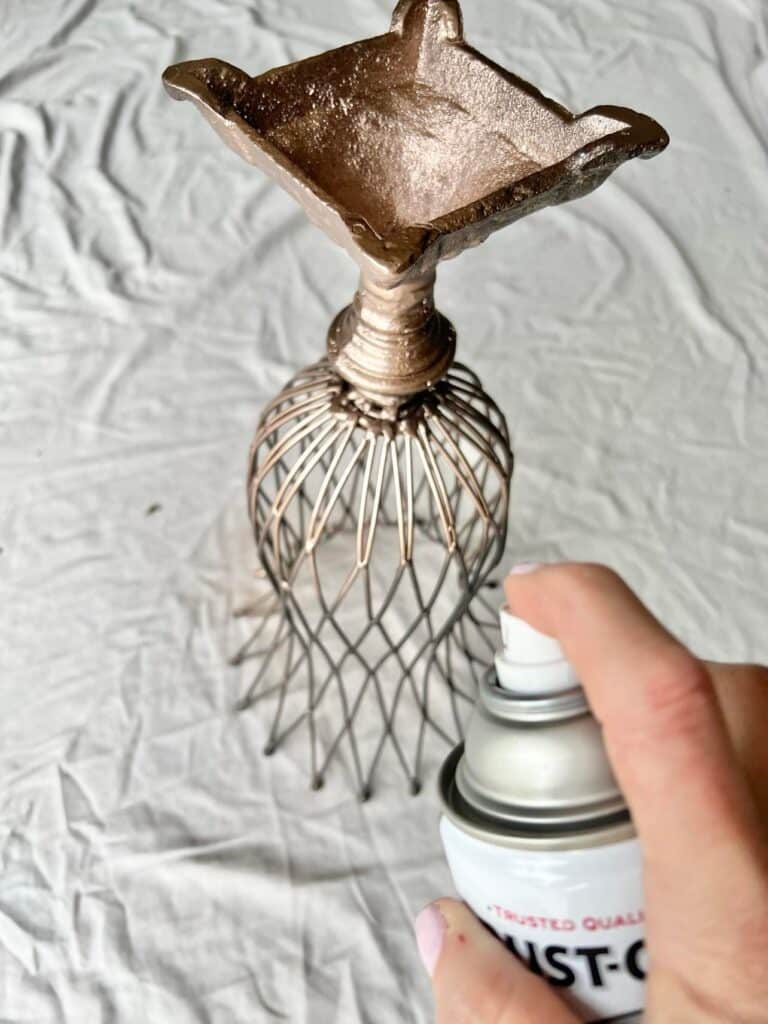 Spray painting the trash to treasure vases with copper spray paint.